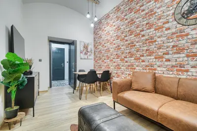 a living room with a brick wall and a couch at KYRA Apartments by Rentez in Prague