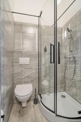 a bathroom with a shower and a toilet and a tub at KYRA Apartments by Rentez in Prague