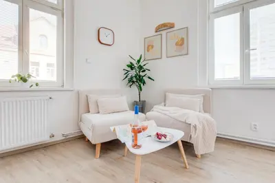 a bedroom with a large bed and a living room at Jane's Cozy Corner Studio in Prague