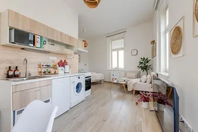a kitchen with a washing machine and a table at Jane's Cozy Corner Studio in Prague