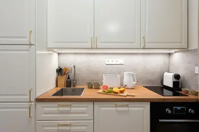 a kitchen with white cabinets and a counter top at Little Oasis in Prague
