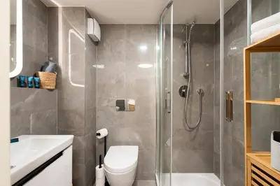 a bathroom with a shower and a toilet and a sink at Little Oasis in Prague