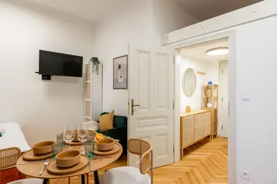 a living room with a table and chairs and a television at Little Oasis in Prague