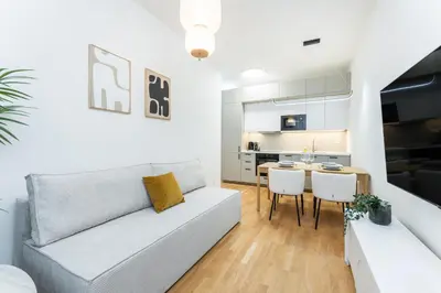 a living room with a couch and a table at Rentero NEW Anděl Skyline Apartment - Prague 5 in Prague