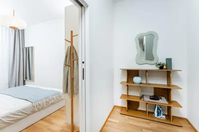 a small bedroom with a bed and a mirror at Rentero NEW Anděl Skyline Apartment - Prague 5 in Prague