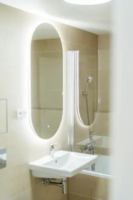 a bathroom with a sink and a mirror at Rentero NEW Anděl Skyline Apartment - Prague 5 in Prague
