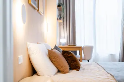 a bedroom with a bed with pillows on it at Rentero NEW Anděl Skyline Apartment - Prague 5 in Prague
