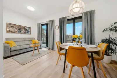 a living room with a table and chairs and a couch at Rotunda Residence - with free weekend parking in Prague