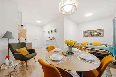a living room with a table and chairs and a couch at Rotunda Residence - with free weekend parking in Prague