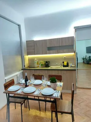 a table with plates and wine glasses in a kitchen at Sophia apartment in Prague