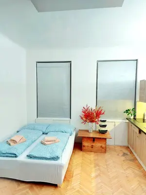 a bedroom with a bed with blue sheets and a table at Sophia apartment in Prague