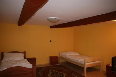 two beds in a room with yellow walls at Podřipská Farma in Roudnice nad Labem