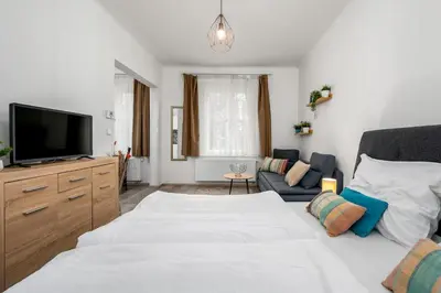 a bedroom with a bed and a tv and a couch at Serenity Suite Prague in Prague