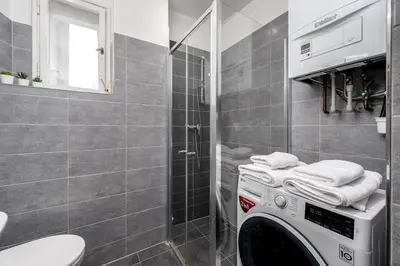 a washing machine in a bathroom with a shower at Serenity Suite Prague in Prague