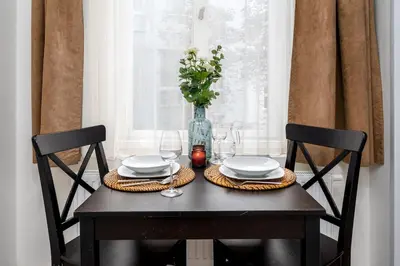 a table with two chairs with plates and a vase at Serenity Suite Prague in Prague