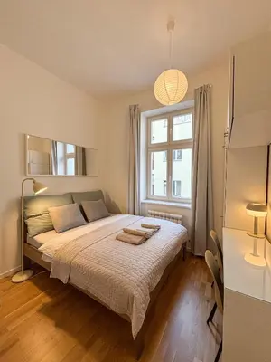 a bedroom with a large bed and a window at Museum Park Apartment II in Prague