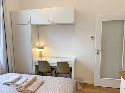 a bedroom with a bed and a desk with two towels at Museum Park Apartment II in Prague