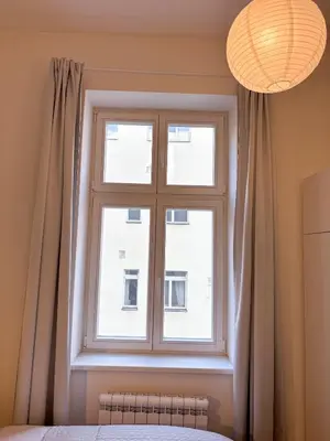 a window in a room with curtains and a bed at Museum Park Apartment II in Prague