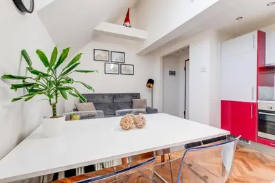 a living room with a white table and a plant at Rooftop Apartment, Vinohrady, City Center in Prague