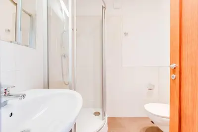 a white bathroom with a sink and a shower at Rooftop Apartment, Vinohrady, City Center in Prague