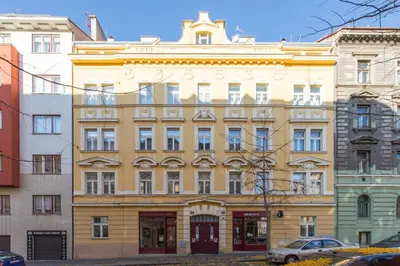 a large yellow building in the middle of buildings at Rooftop Apartment, Vinohrady, City Center in Prague