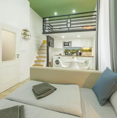 a living room with a couch and a kitchen at HOMELY I 32m2 Central loft I ELEVATOR I SELF CHECK-IN in Prague