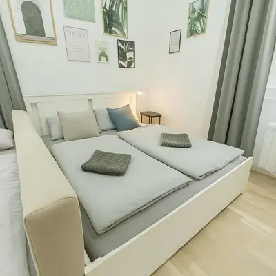 a white bed with two pillows on top of it at HOMELY I 32m2 Central loft I ELEVATOR I SELF CHECK-IN in Prague