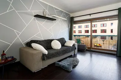 a living room with a couch and a large window at Crown Tiger Penthouse in Prague