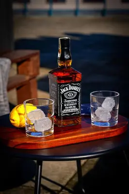 a bottle of whiskey and two glasses on a table at Crown Tiger Penthouse in Prague