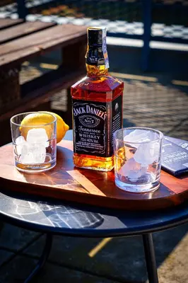 a bottle of whiskey and two glasses on a table at Crown Tiger Penthouse in Prague