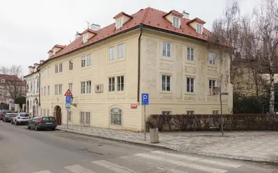 a large white building with a red roof on a street at Apartmán U Černého Beránka in Prague