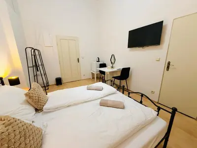two beds in a room with a desk and a television at Zitna Downtown Residence in Prague