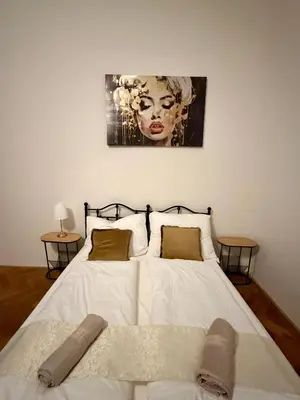 a bedroom with a white bed with a painting on the wall at Zitna Downtown Residence in Prague