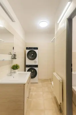 a bathroom with a sink and a washing machine at Ideal for Big Groups, Modern 14 Guest Apartment Near Prague in Rakovník