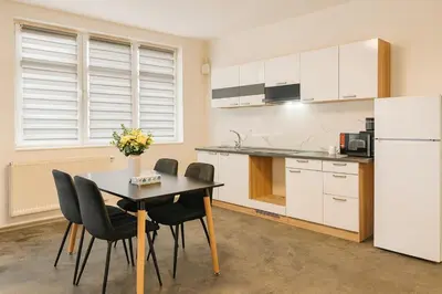 a kitchen with a table and chairs and a refrigerator at Ideal for Big Groups, Modern 14 Guest Apartment Near Prague in Rakovník