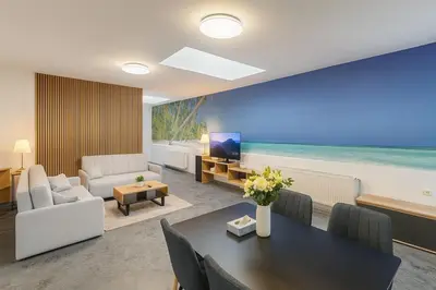 a living room with a table and a view of the ocean at Ideal for Big Groups, Modern 14 Guest Apartment Near Prague in Rakovník