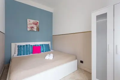 a bedroom with a bed with blue and pink pillows at Legerova 33 Apartments in Prague