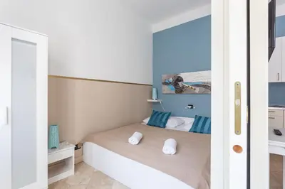 a small bedroom with a bed with blue walls at Legerova 33 Apartments in Prague