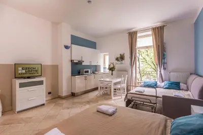 a living room with two beds and a kitchen at Legerova 33 Apartments in Prague