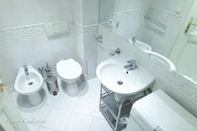 a white bathroom with a sink and a toilet at Old Town Square Apartment in Prague