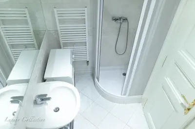 a white bathroom with a sink and a shower at Old Town Square Apartment in Prague