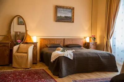 a bedroom with a bed and a chair and a mirror at Zámek Lobeč in Lobeč