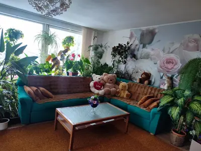 a living room with a blue couch and plants at Оазис in Jíloviště