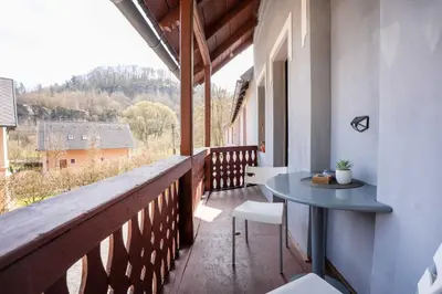 a balcony of a house with a table and chairs at U báby Šubrový in Kokořín