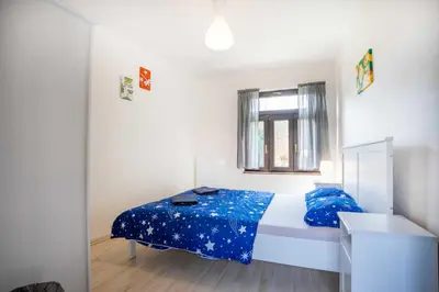 a bedroom with a bed with blue sheets and a window at U báby Šubrový in Kokořín
