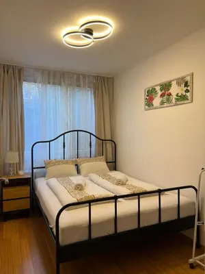 a bedroom with a bed with a black frame and a window at Cozy City Stay - Central Apartment in Prague