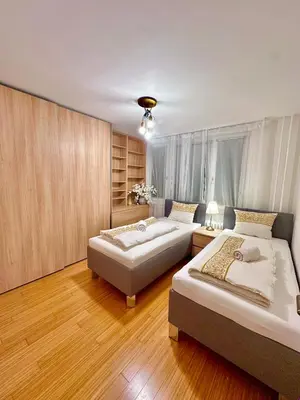 two beds in a room with wooden floors at Cozy City Stay - Central Apartment in Prague
