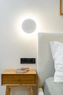 a small table with a chair next to a bed at Rentero Riverside Serenity Residence - Prague 7 in Prague