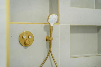 a bathroom with a gold faucet on a sink at Rentero Riverside Serenity Residence - Prague 7 in Prague