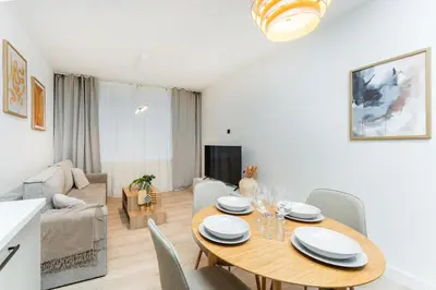 a dining room and living room with a table and chairs at Rentero Riverside Serenity Residence - Prague 7 in Prague